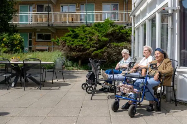 Bewoners woonzrogpark Swaenesteyn genieten van de zon buiten in de tuin
